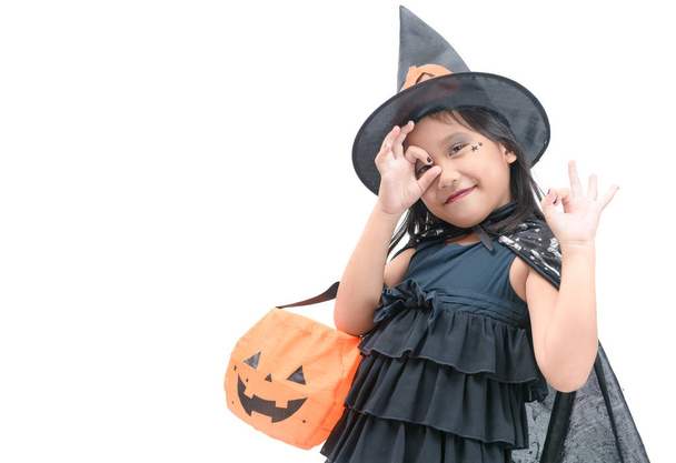 grappige kind meisje in heks kostuum voor Halloween met pompoen Jack geïsoleerd op witte achtergrond - Foto, afbeelding