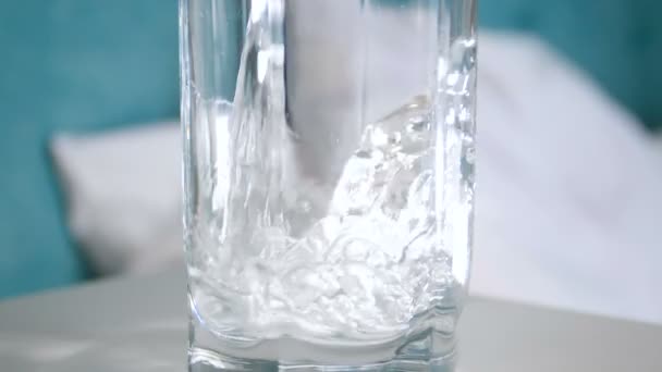Lähikuva hidastettuna video täyttämällä lasi kylmällä kirkkaalla vedellä yöpöydällä
 - Materiaali, video