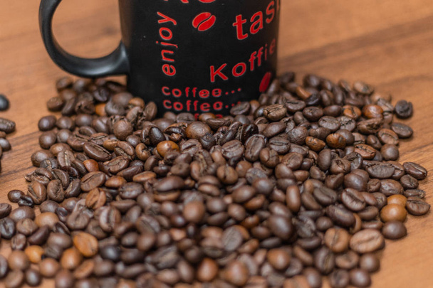 A cup of coffee with fried beans on a wooden background. Top view with copy for text - Photo, Image