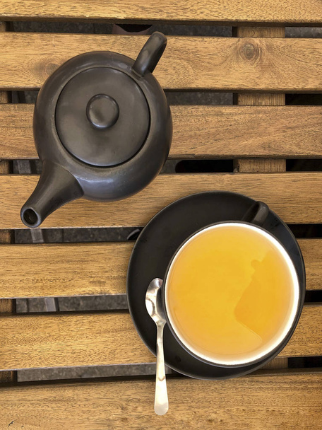 чайник і чашка зеленого чаю на дерев'яному столі
 - Фото, зображення