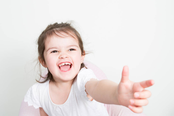 Kız güzel heyecanlı çocuk elini tut mutlu beyaz arka plan üzerinde izole - Fotoğraf, Görsel