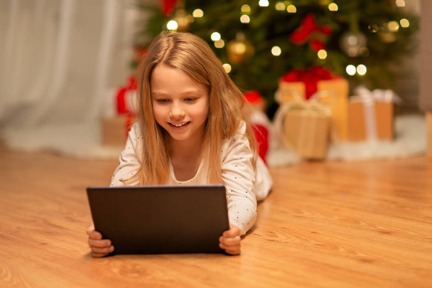 smiling girl with tablet pc at christmas home - Φωτογραφία, εικόνα