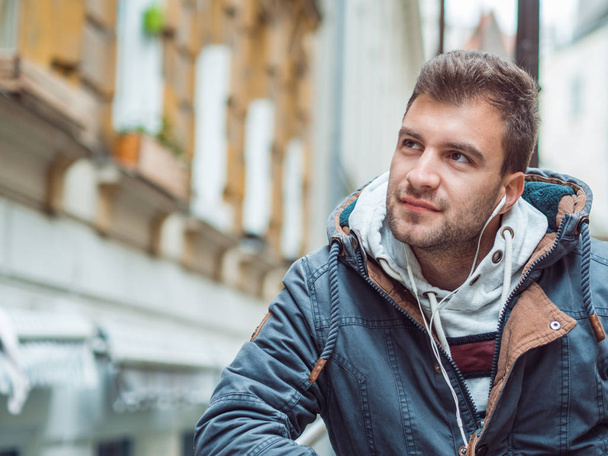 Portrait of young man in the street listening music from his phone. Copyspace - Foto, imagen