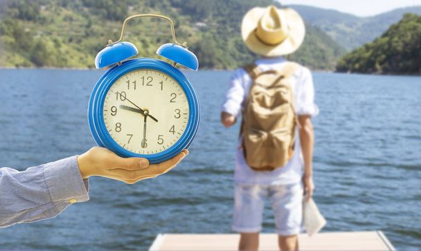 hand-clock and traveler, concept of vacation time and adventure - Photo, Image