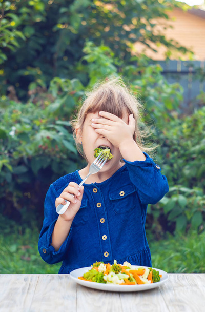 A gyerek zöldséget eszik. Nyári fotó. Szelektív összpontosítás - Fotó, kép