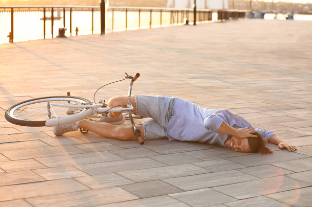 Man fallen off his bicycle on street - Фото, зображення