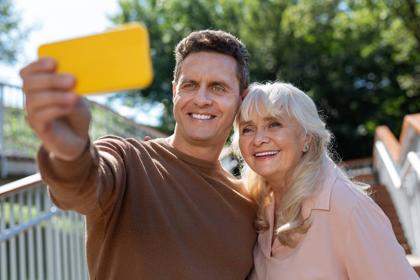 Pleased young man taking selfie photo with mom - Zdjęcie, obraz