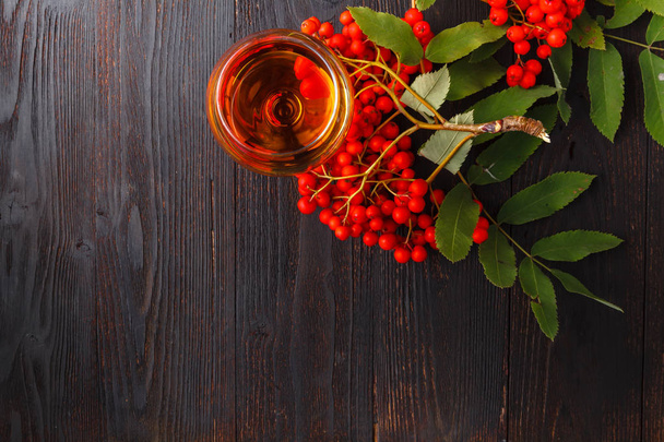 Handmade rowan-vodka and red berries of rowan tree - Photo, Image