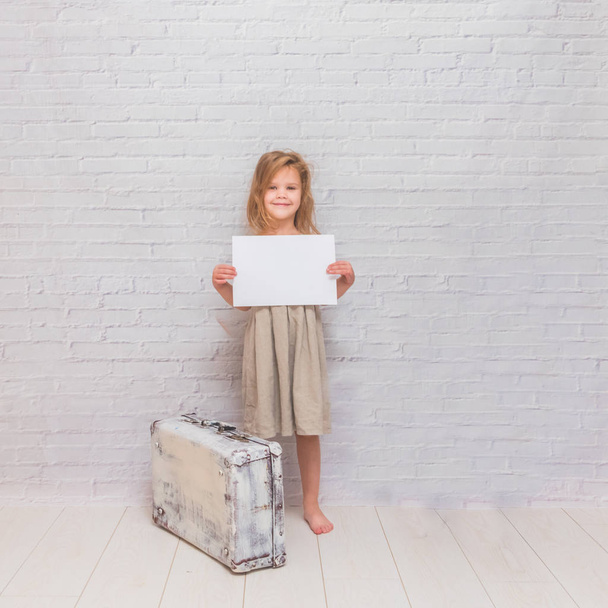Copy Space girl, child with suitcase on white brick wall background - Zdjęcie, obraz