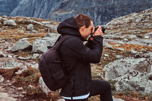 Природа фотограф турист с камерой съемки, стоя на горе
. - Фото, изображение