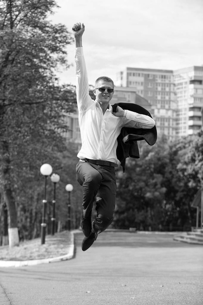 Happy man jump on street. Businessman celebrate victory on cityscape background. Successful manager smile in formal suit. Business fashion and style. Success victory and triumph sense of freedom - Foto, Imagen
