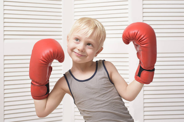 Lovely blond boy in red boxing gloves. Sports concept - Fotoğraf, Görsel
