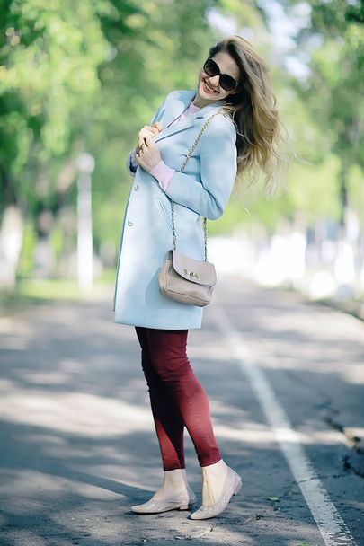 beautiful blonde woman wearing stylish coat in park  - Фото, изображение