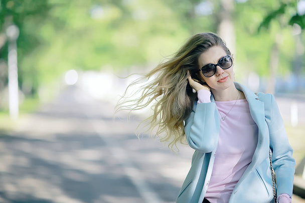 portrait of beautiful young woman wearing sunglasses in spring park  - Foto, Imagen