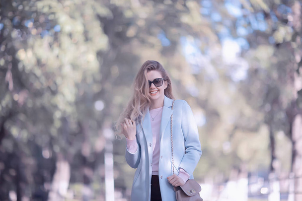 portrait of young happy woman wearing stylish coat in spring park  - Φωτογραφία, εικόνα