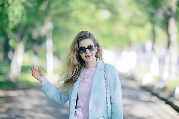 portrait of young happy woman wearing stylish coat in spring park  - Foto, imagen