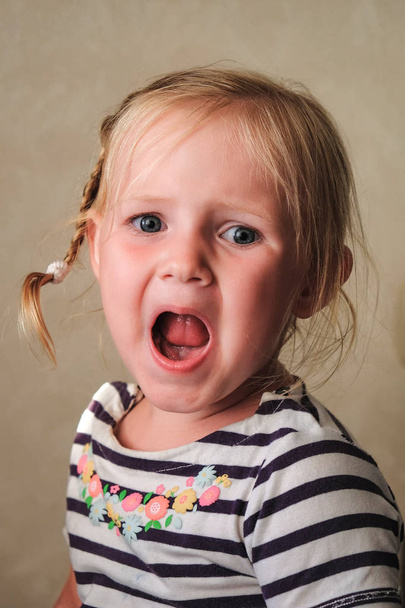 irritabile bambino infelice è seduto e piange ad alta voce
 - Foto, immagini