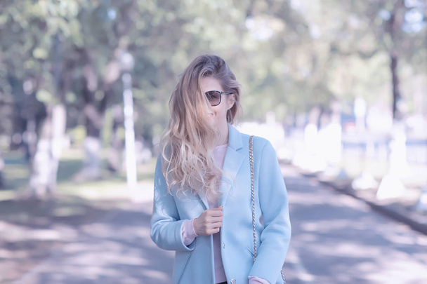 retrato de jovem mulher feliz vestindo casaco elegante no parque de primavera
  - Foto, Imagem