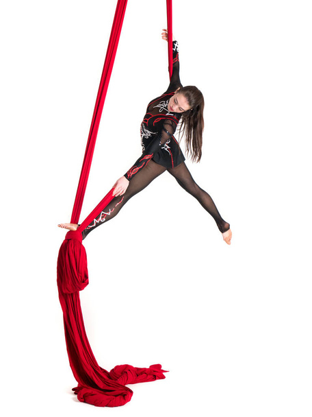 Woman hanging in aerial silks, isolated on white - Foto, afbeelding