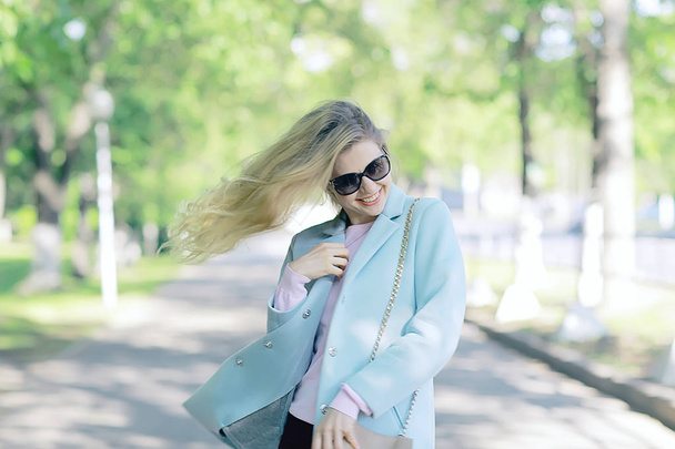 portrait of beautiful young woman wearing sunglasses in spring park  - Foto, imagen