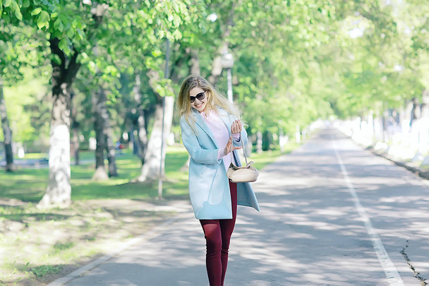 beautiful blonde woman wearing stylish coat in park  - Fotó, kép
