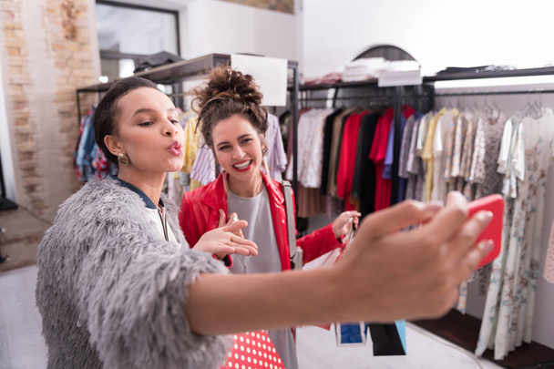 Positive two female friends buying fashionable clothes - Foto, Imagem