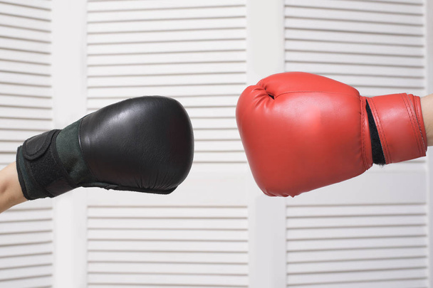 Black and red boxing gloves. Confrontation. White background - Foto, afbeelding