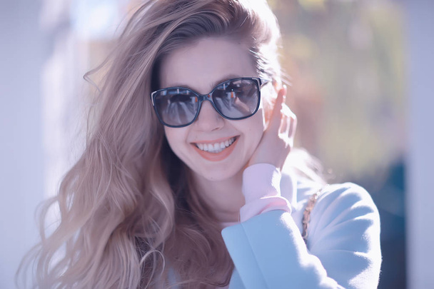 portrait of beautiful young woman wearing sunglasses in spring park  - Foto, immagini