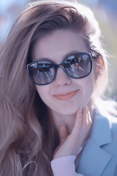 beautiful blonde woman wearing sunglasses in park - Фото, зображення