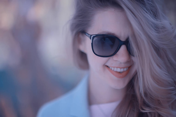 beautiful blonde woman wearing sunglasses in park - Foto, afbeelding
