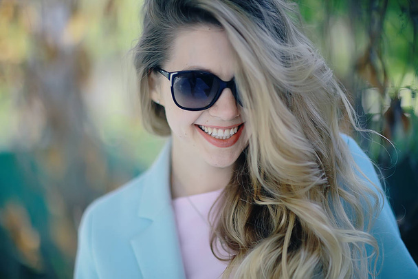 beautiful blonde woman wearing stylish blue coat in park - Foto, Imagem