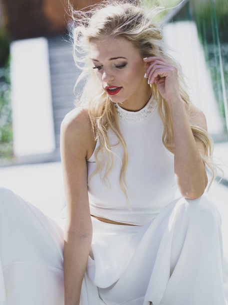 Elegant fashionable woman presenting trendy urban outfit. White crop top and trousers culottes. - Foto, Bild