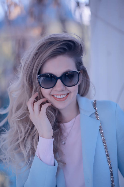 portrait of beautiful young woman wearing sunglasses in spring park  - Фото, зображення