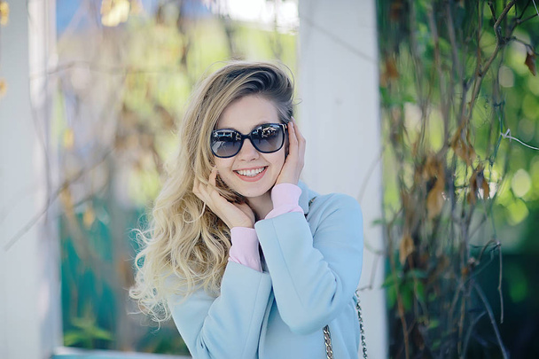 beautiful blonde woman wearing stylish blue coat in park - Foto, Imagem
