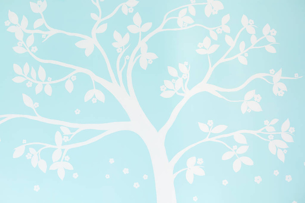 Shot of blue wallpaper with white tree printed for your design or advertising content. Empty room. Nice pattern. Light colours. Nobody poses - Φωτογραφία, εικόνα