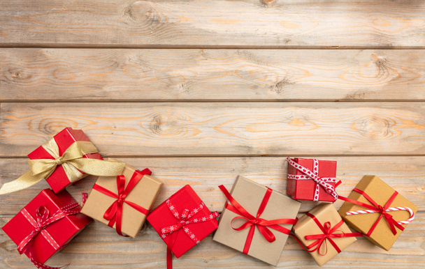 Рождество. Подарочные коробки с красными лентами на деревянном фоне, пространство для копирования, вид сверху
 - Фото, изображение