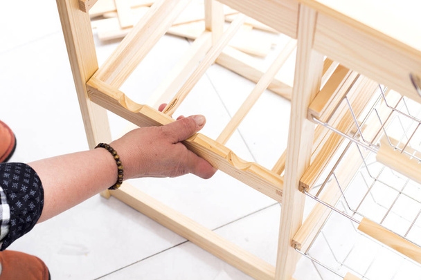 cropped image of carpenter person repairing wardrobe table shelves  - Foto, afbeelding