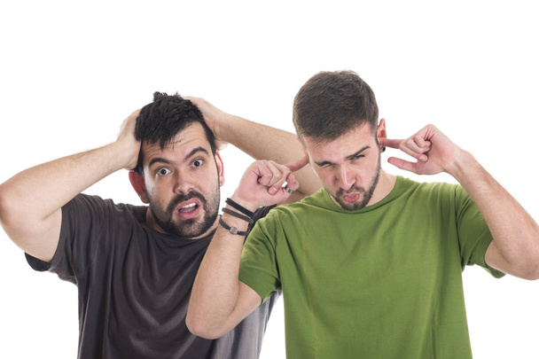 Crazy amazed man holding hands on head, looking at camera while other man covering ears with fingers  - Foto, Imagem