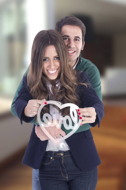 Закохана пара на день Святого Валентина проведення підписати форму серця і обіймати  - Фото, зображення