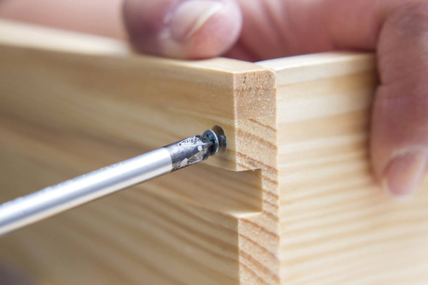 carpenter person using screwdriver tool while repairing wardrobe  - Valokuva, kuva