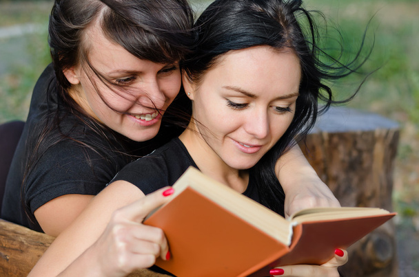 zwei enge Freundinnen genießen ein Buch - Foto, Bild