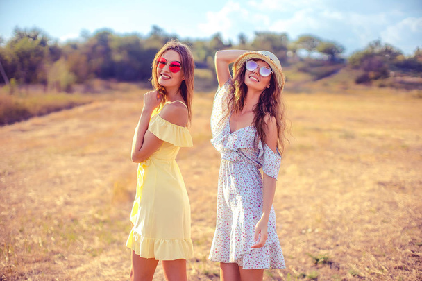 two pretty girlfriends in summer dresses - Photo, image