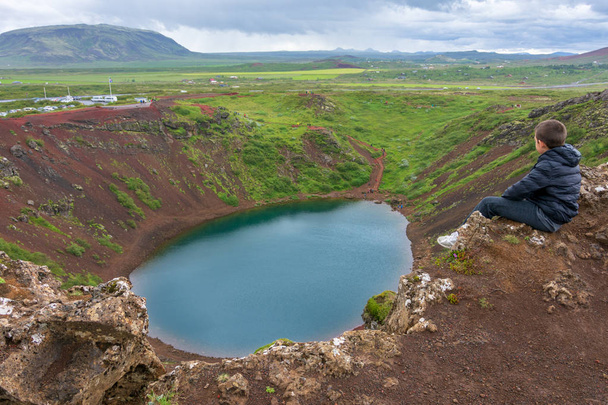 Mladý muž si užívat výhled na sopku Kerid a kráter v Golden kruhu na jihovýchodě Islandu - Fotografie, Obrázek