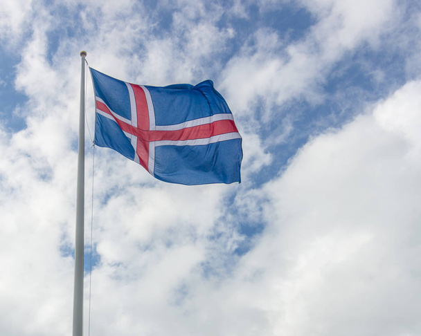Iceland flag of red and white cross on blue backgroumd hanging proudly in the windy Icelandic weather - Foto, immagini