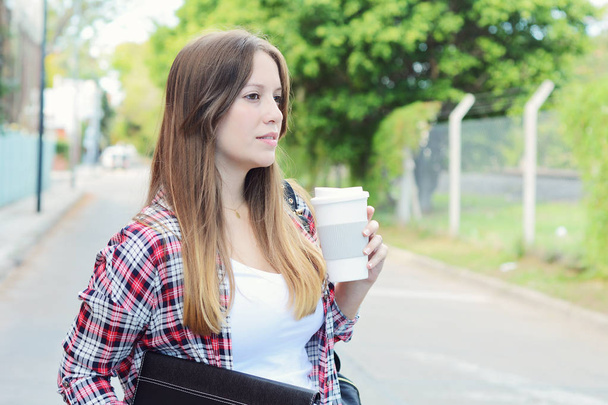 Portrait of beautiful woman holding paper coffee cup in the street. Urban city scene. Outdoors - Fotoğraf, Görsel
