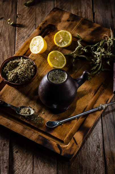 Yerba mate - Latin American hot drink herb tea in clay mug on wooden table - Photo, image