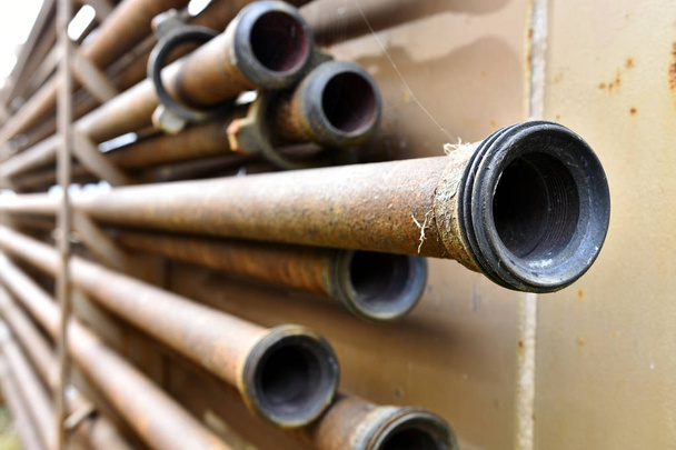 Une image abstraite de vieux tuyaux industriels rouillés sur un rack
.  - Photo, image