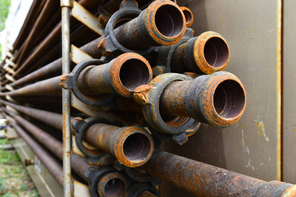 Uma imagem abstrata de antigos tubos industriais enferrujados em um rack
.  - Foto, Imagem