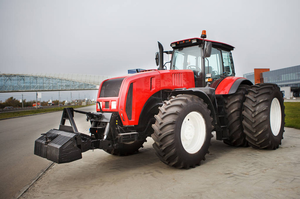 Új piros modernizált mezőgazdasági traktor, nagy kerekekkel, a szabadtéri kiállítás - Fotó, kép