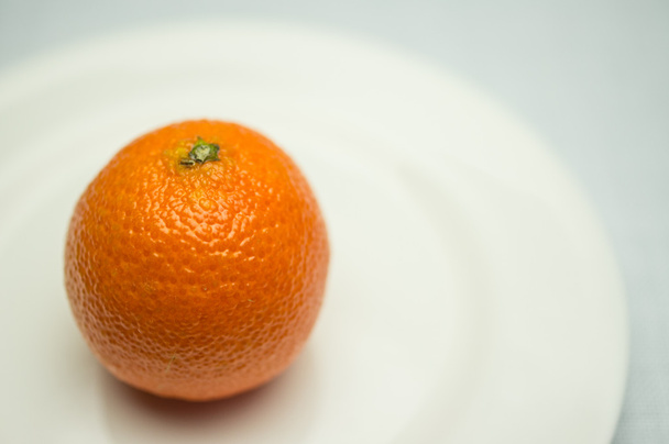 Mandarino su un piatto bianco
 - Foto, immagini
